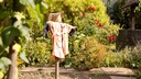 Eine Vogelscheuche steht in einem Garten