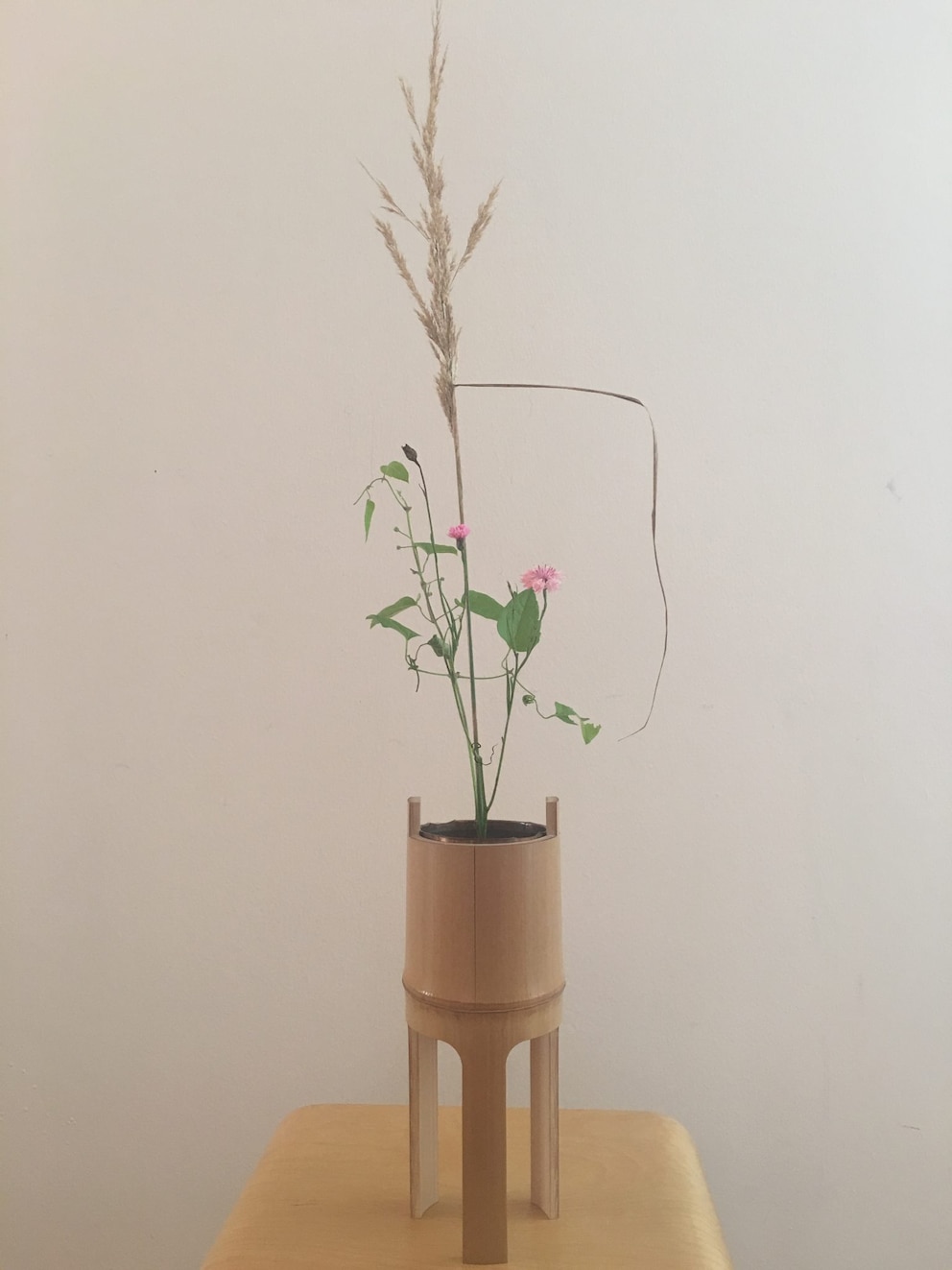 Ein Ikebana in einem hohen Gefäß