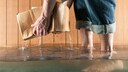 Ein Mensch hebt eine Kiste aus dem Wasser