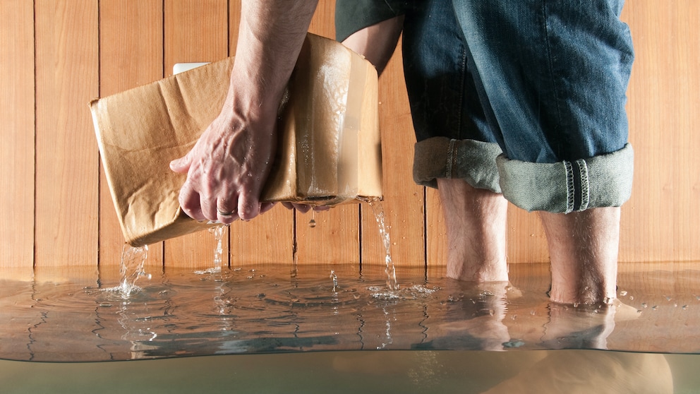 Ein Mensch hebt eine Kiste aus dem Wasser