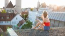 Eine Frau pustet Seifenblasen vom Dach