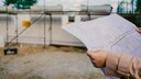 Baunebenkosten: Eine Frau hält einen Bauplan in den Händen