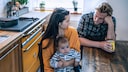 Eine Familie sitzt traurig am Tisch