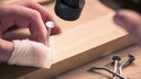 Finger in Bandage beim Hämmern