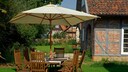 Sonnenschirm Sicherheit: Eine Sitzgruppe unter einem Sonnenschirm in einem Bauerngarten