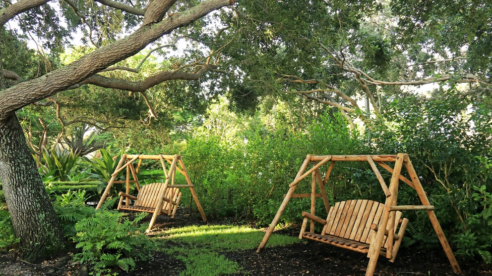 Hollywoodschaukel: Zwei Hollywoodschaukeln aus Holz im Garten