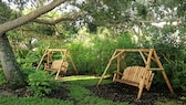 Hollywoodschaukel: Zwei Hollywoodschaukeln aus Holz im Garten