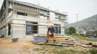 Arbeiter wartet auf einer Baustelle auf Baustoffe
