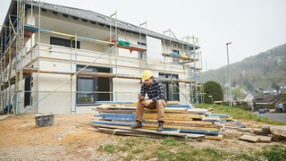 Arbeiter wartet auf einer Baustelle auf Baustoffe