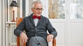 Ein Senior sitzt auf einem Stuhl