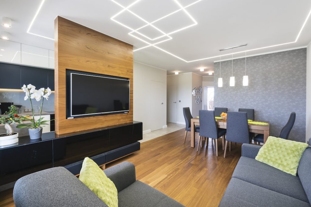 A living wall as a room divider with wood paneling between the kitchen and living room