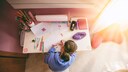 Ein Kind malt an einem kindergerechten Tisch