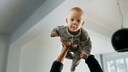 Baby wird auf dem Arm hochgehoben