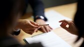 Ein Stift wird zur Unterschrift gereicht