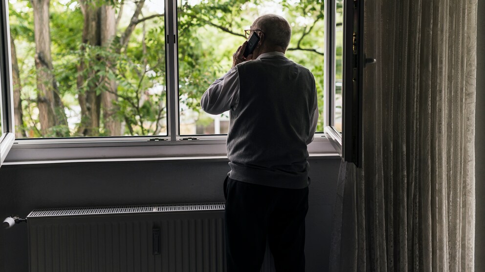 Ein Senior schaut aus dem Fenster