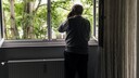 Ein Senior schaut aus dem Fenster