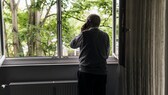 Ein Senior schaut aus dem Fenster