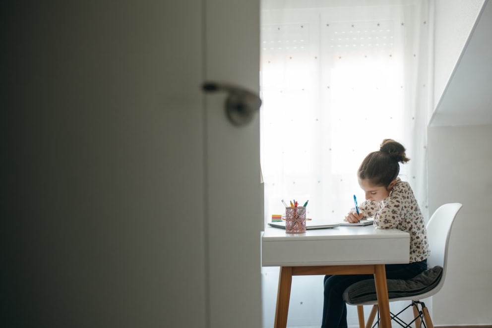 Young girl sitting at a desk and writing