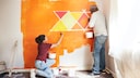 Menschen streichen eine Wand orange