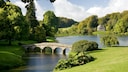Gartenkunst: Blick auf Fluss mit steinerner Brücke in einem englischen Landschaftsgarten