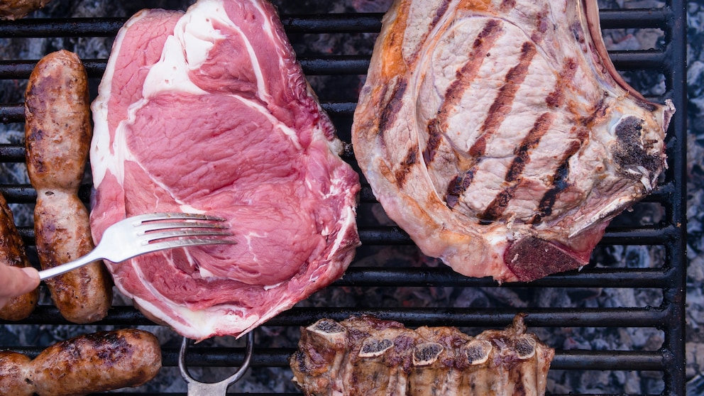 Steaks auf dem Grill und eine Gabel