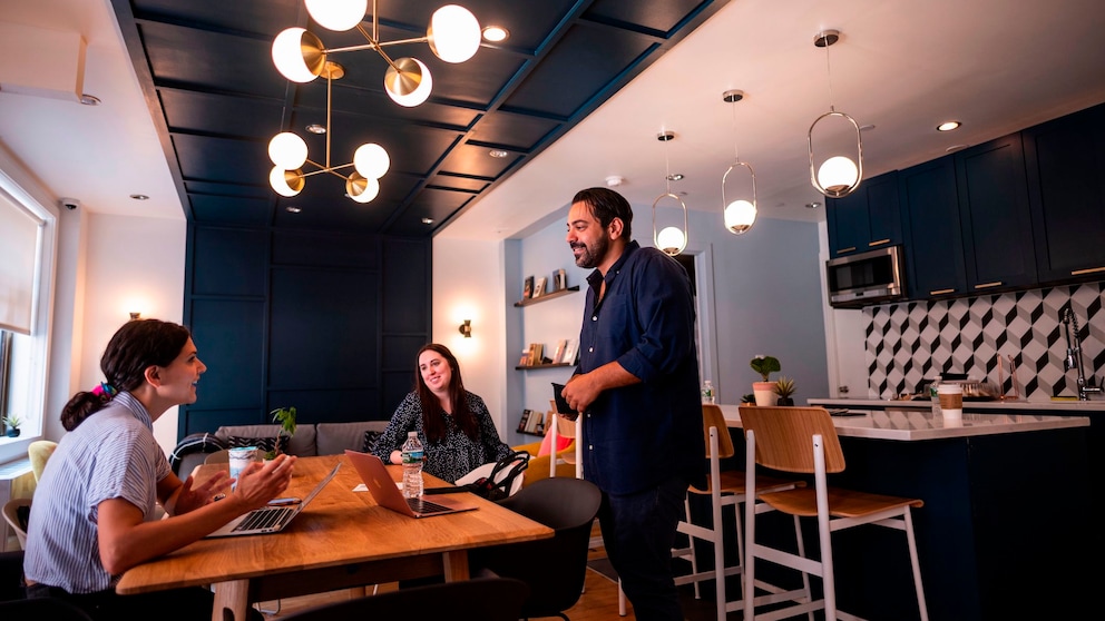 Verschiedene Menschen treffen sich in einem offenen Raum in einem Co-Living-Space