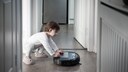 Kind mit Staubsaugerroboter