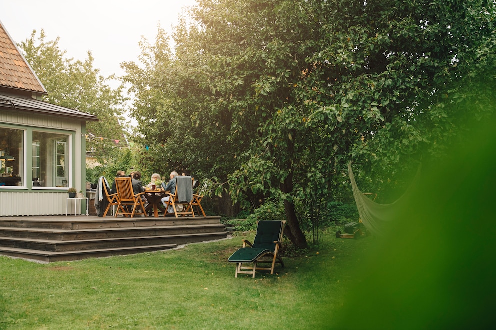 Eine Terrasse, die nach hinten in den grünen Garten führt