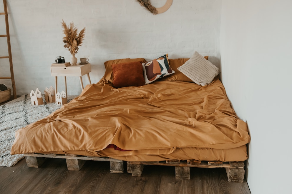 Ein natürlich eingerichtetes Schlafzimmer bei dem das Bett mal in einer Raumecke steht