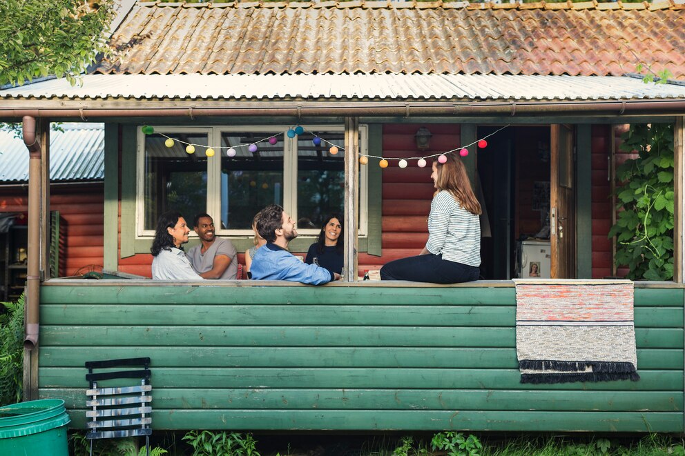 Menschen, die sich auf der Terrasse eines Holzhaus befinden