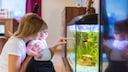 Frau und Baby schauen sich gemeinsam ein Aquarium an