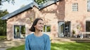 Frau vor Haus