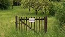 Zaun mit „Zu Verkaufen“-Schild