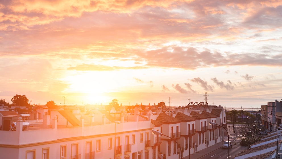 Solardachziegel: Sonnenuntergang hinter Hausdächern