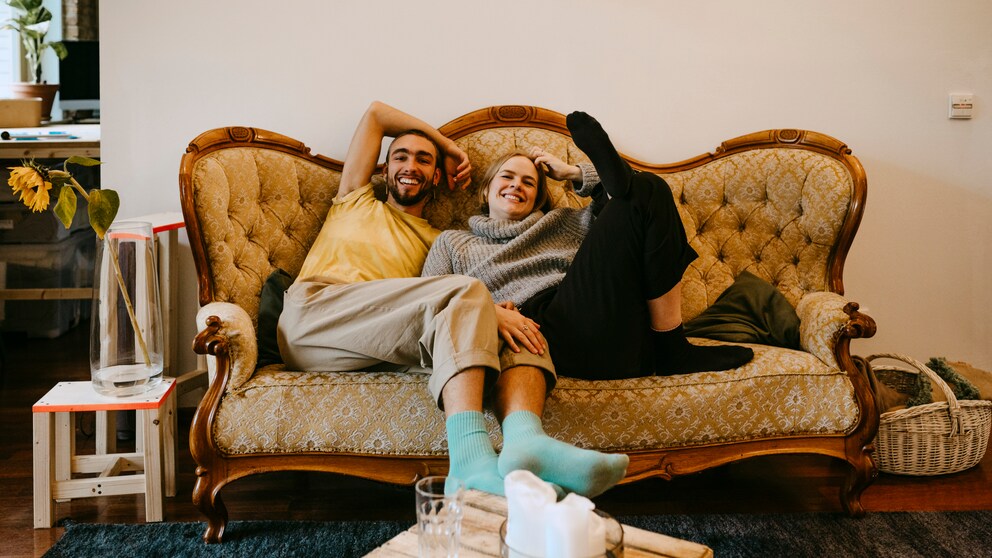 Millennials sitzen auf einem alten Sofa und lachen