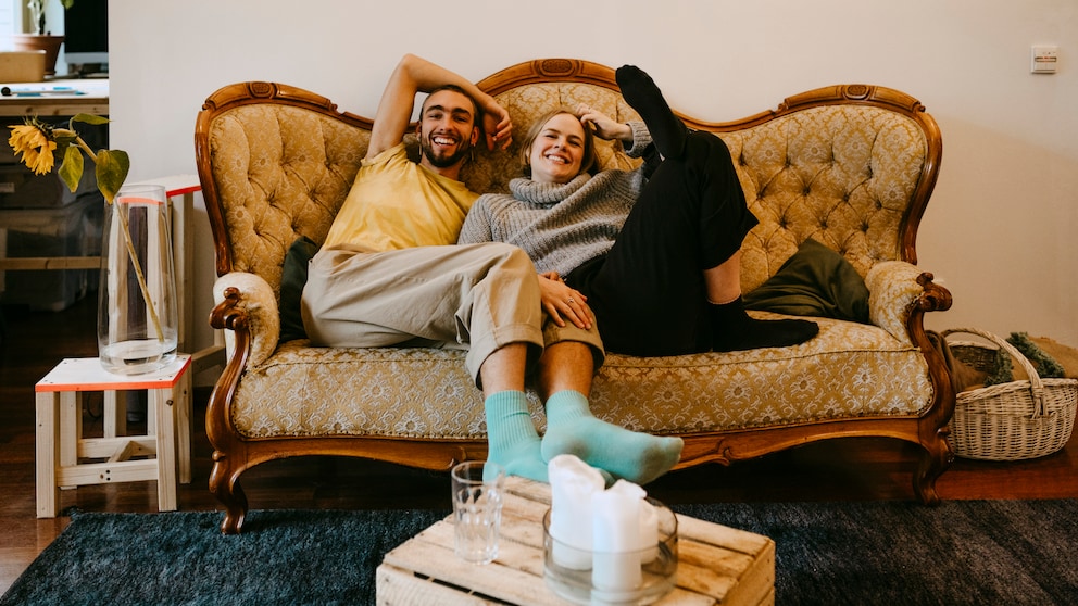 Millennials sitzen auf einem alten Sofa und lachen