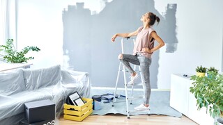Frau vor einer gestrichenen Wand in neuer Wohnung