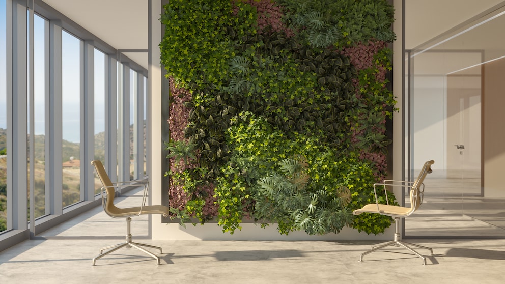 Vertical Gardening ist eine Art der Bepflanzung, mit der Wände begrünt werden können. Vor einer Pflanzenwand stehen zwei Bürostühle