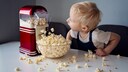 Popcorn Häuser dämmen: Ein kleiner Junge sitzt verwundert vor einer Popcorn-Maschine
