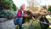 Frau mit Laub im Garten