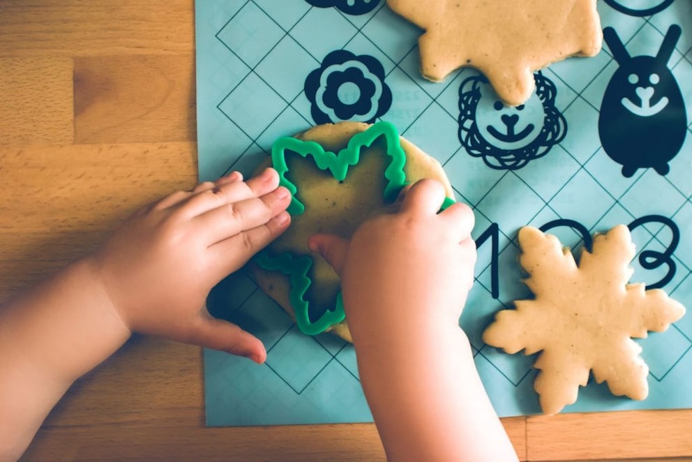 Small child cutting out cookies with a cookie cutter