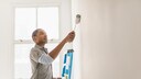 Mann streicht Wand