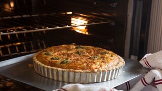 Backblech Rost: Ofen mit Rost und Backblech, auf dem eine Quiche in Auflaufform steht