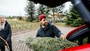 Mann lädt Weihnachtsbaum ins Auto
