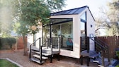 Tiny House: Ein Tiny House oder Mikrohaus mit Fensterzeile zum Boden und zwei Treppen