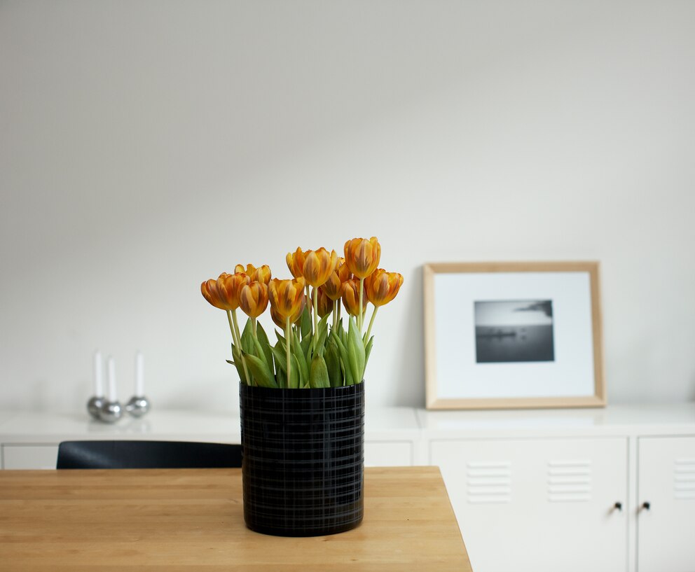 Ein Strauß Tulpen in schlichter Vase auf einem Tisch