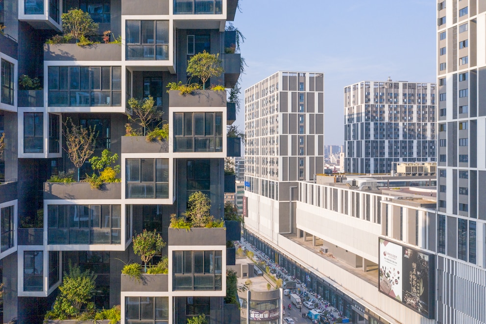 Hochhaus mit Wald: Hochhaus mit Bäumen und Begrünung auf den Balkonen