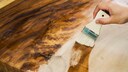 Holzoberfläche, die mit einem Pinselauftrag behandelt wird
