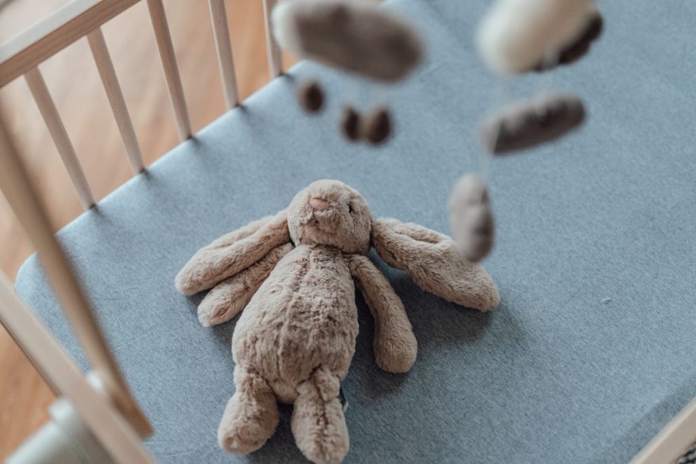 Mattress with light blue sheet and stuffed animal
