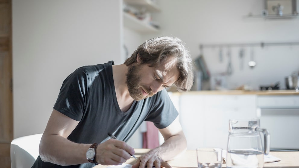 Grundsteuererlass: Ein Mann füllt Formulare aus